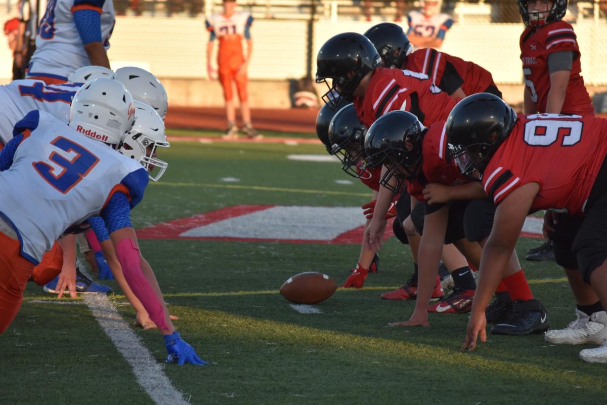 B team football players line up and prepare for the ball to be snapped and the play to begin.