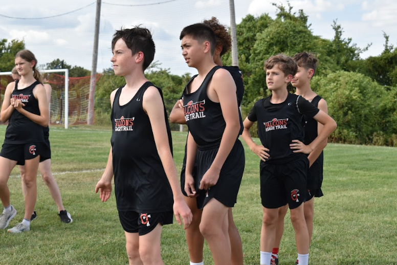 Sawyer Astry (8) and Jared Fox (8) listen to Coaches talking while they prepare for the OTMS invitational meet.